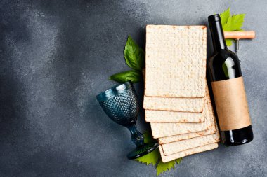 Kosher şarabı ve Matzoh Yahudi ekmeği. Üst görünüm, gri arkaplanda.
