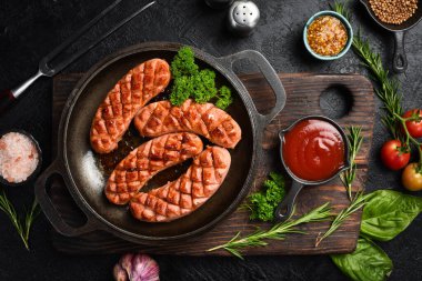 Dökme demir tavada kızarmış tavuk sosisi. Ev yapımı yemek. Üst görünüm.