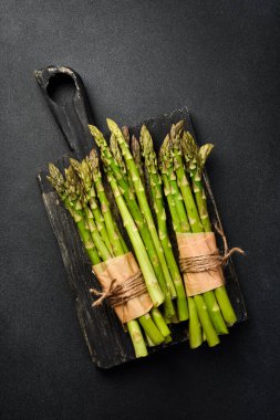Üç paket taze organik kuşkonmaz. Beton bir arka planda. Üst görünüm.