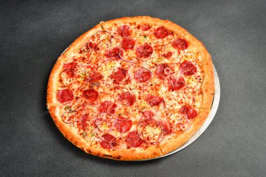 Sucuklu salamlı İtalyan pizzası. Üst Manzara. Metin için boş alan. Gri taştan bir arka planda.