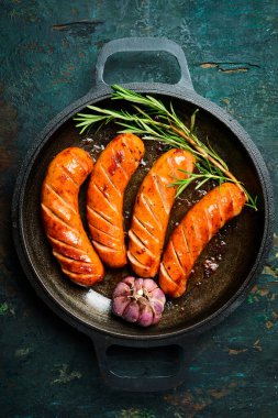 Demir tava ve kızarmış domuz sosisi. Üst Manzara. Barbekü veya ızgara arkaplanı.