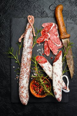 Tahta tabakta kesilmiş nefis bir sosis. Kapatın. Üst görünüm.