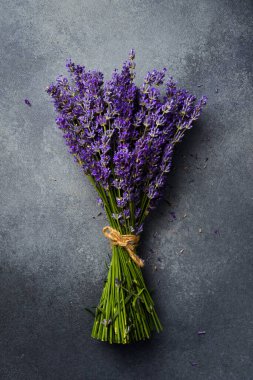 Bir demet lavanta çiçeği. Gri beton arka planda mis kokulu mor çiçekler. Üst görünüm.