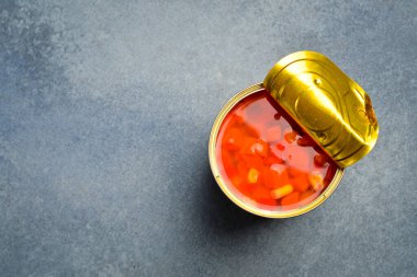 Metal bir kavanozda kırmızı domates turşusu. Yiyecek stokları. Gri beton arka planda.