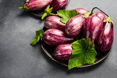 Organik patlıcanlı metal tepsi. Yan görüş. Gri beton arka planda.