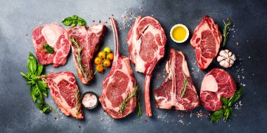 Baharatlı ızgara için çiğ biftek çeşitleri: Tomahawk bifteği, Ribeye, T-bone ve Ossobuco bifteği. Et arkaplanı.