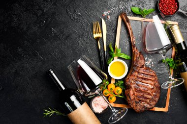Şişe şarap, bardaklar ve biftek. Siyah Angus bifteği ve yıllanmış şarap. Üst görünüm.