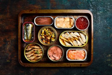 Farklı balık ve deniz ürünleriyle konserve kutuları: balık, havyar, morina ciğeri, lahanalar. Üst görünüm