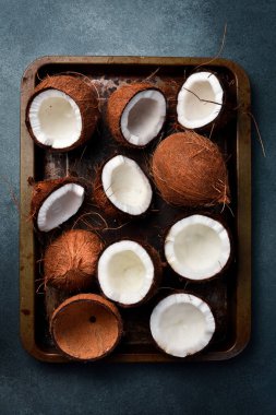 Metal bir tepside taze hindistan cevizleri. Tropik fındıklar yakın plan. Karanlık bir arka planda.