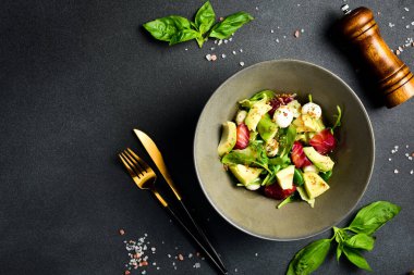 Balık, mozarella peyniri ve ıspanaklı renkli salata. Üst görünüm.