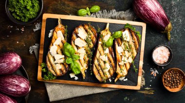 Peynirli ve baharatlı fırında patlıcan. Izgara sebze. Gri beton arka planda.