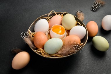 Bir kase çiğ tavuk yumurtası. Yiyecek proteinle zenginleştirilmiş. Siyah taştan bir arka planda. Kapat..