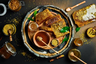 Yuvarlak ahşap bir kutuda arıcılık ürünleri. Bal 'ı bal peteğine, çiçek arısı polenine ve bala çevir. Üst görünüm.