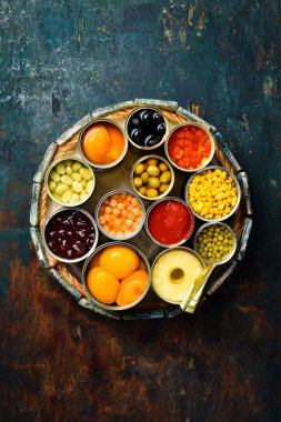 Teneke kutularda çeşitli sebzeler, et ve meyveler. Tahta bir kutuda. Yemek afişi. Üst görünüm.