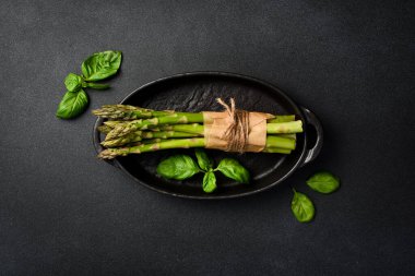 İçinde taze kuşkonmaz olan siyah taş bir kase. Üst görünüm.
