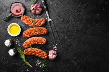 Metal barbekü çatalı ve arka planda ızgara sosis. Kalabalık gezinme, tasarım veya metin için boş alan.