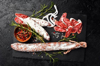 Tahta tabakta kesilmiş nefis bir sosis. Kapatın. Üst görünüm.