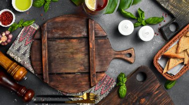 Taştan siyah aşçılık geçmişi. Sebze ve baharatlı mutfak tahtası. Siyah taştan bir arka planda. Üst görünüm