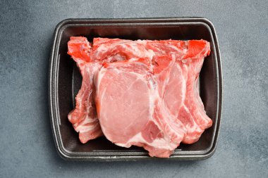 Çiğ et. Kemiğin üzerinde taze domuz filetosu. Marketten alınmış plastik bir kapta et. Yakın plan..