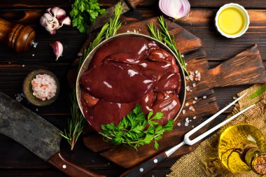 Çiğ hindi ciğeri ile seramik kase. Üst manzara, yakın plan. Siyah desenli taş arka planda.