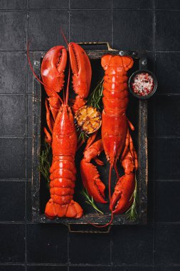 Limonlu ıstakoz, yenmeye hazır. Siyah taştan bir arka planda.