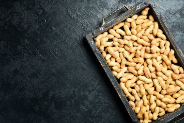 Kabuksuz fıstıklarla dolu tahta kutu. Gri beton arka planda. Fındık Yakın plan.