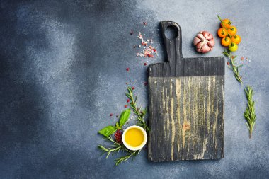 Gri taş pişirme arka planı. Mutfak kesim tahtası, baharatlar ve sebzeler. Üst Manzara. Metnin için boş yer.