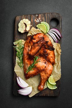 Biberiyeli ızgara tavuk ve ahşap bir tahtada baharatlar. Geleneksel şenlik yemeği.