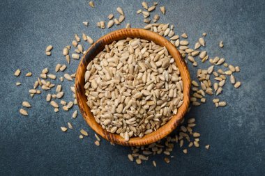 Kabuğu soyulmuş ayçiçeği tohumlarıyla dolu ahşap bir kase. Yakın plan. Organik yiyecekler.