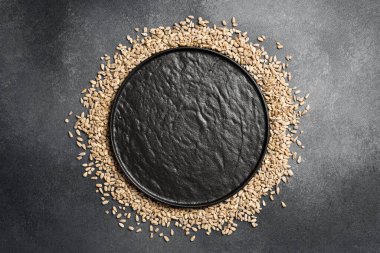 Yuvarlak bir çerçeveye dizilmiş ayçiçeği tohumları. Metin için boş alan. Gri beton arka planda. Yakın plan. Organik yiyecekler.