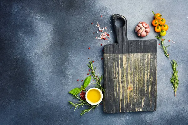 Gri taş pişirme arka planı. Mutfak kesim tahtası, baharatlar ve sebzeler. Üst Manzara. Metnin için boş yer.
