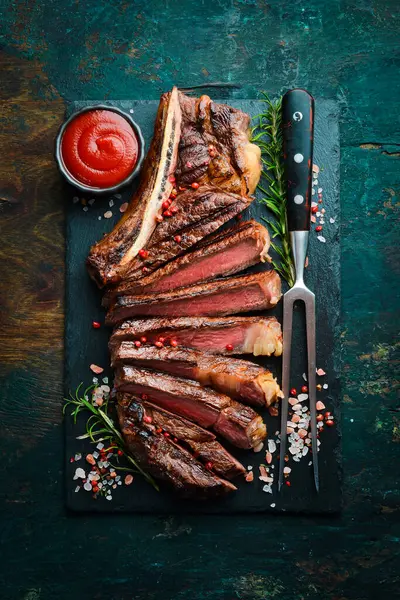 Angus bifteği. Biberiye ve tereyağlı dilimlenmiş biftek. Üst görünüm.