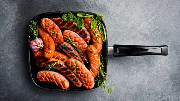 Metal ızgarada domuz eti, biftek ve tavuk sosisi. Üst görünüm, metin için boş alan.