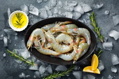 Buzlukta limonlu çiğ karides. Koyu dokulu bir arkaplanda.