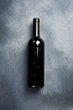 Masadaki şişede kırmızı şarap, mesaj için boş yer. Şişe içinde yıllanmış şarap. Üst görünüm.
