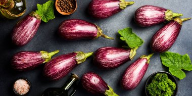 Organik taze patlıcan. Mor patlıcanlara yakın çekim. Üst Manzara. Gri beton arka planda.