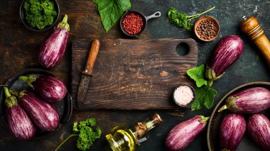 Sebzelerin arka planı. Yeni hasat edilmiş bir patlıcan pişirmeye hazır. Organik sebzeler. Üst görünüm.