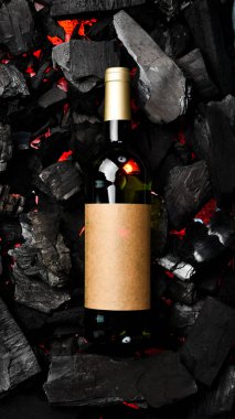 Kömürün arka planında şişe içinde beyaz şarap. Metin için boş alan. Üst görünüm.