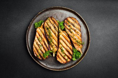 Bir tabak ızgara patlıcan. Izgara sebze. Üst Manzara. Gri beton arka planda.