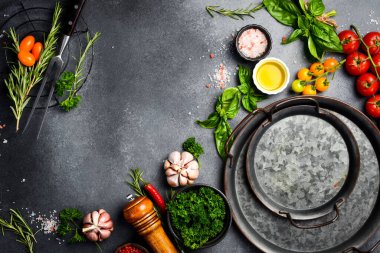 Gri taş masa ve aşçılık arka planı. Baharat ve sebze. Üst Manzara. Metnin için boş yer.