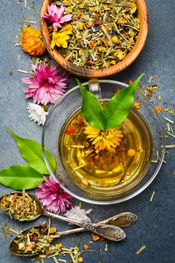 Bir bardak çiçek çayı. Gri beton arka planda. Dikey fotoğraf.