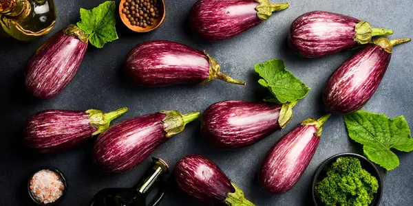 Organik taze patlıcan. Mor patlıcanlara yakın çekim. Üst Manzara. Gri beton arka planda.