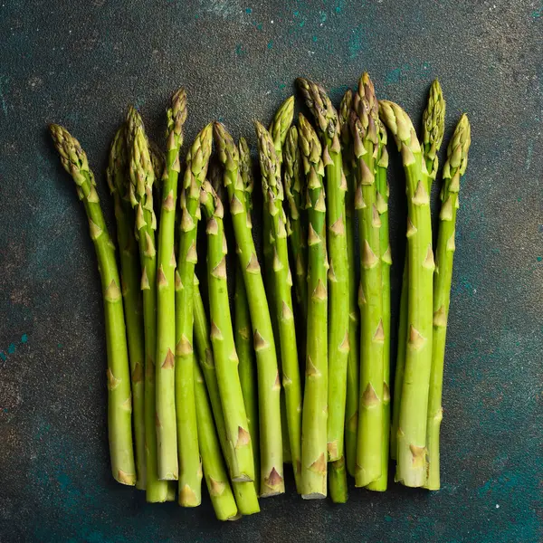 Koyu arka plan üzerinde taze yeşil kuşkonmaz