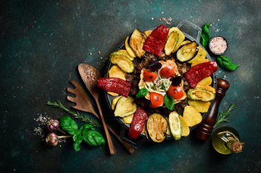 Saj - geleneksel Azerbaycan yemekleri. Metal bir tavada kuzu saj. Metin için boş alan. Karanlık bir arka planda.