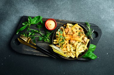 Metal tavada kızarmış patates. Karanlık bir arkaplanda, yakın plan.