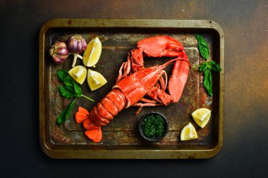 Siyah tahtada limonlu ızgara ıstakoz. Koyu bir ahşap masada