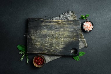 Mutfak eski kesme tahtası. Kahverengi tahta. Mutfak aletleri. Karanlık bir arka planda.