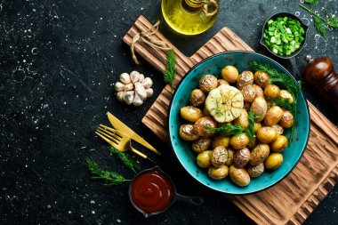 Sarımsaklı kızarmış patates. Jeera Aloo, içinde bebek patatesler olan bir Hint mutfağı. Taş bir arka planda.