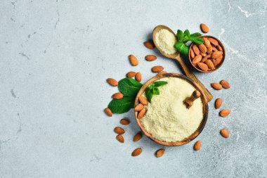 Badem unu ve fındıklı tahta kaşık. Beton bir arka planda. Üst Manzara. Boşluğu kopyala.