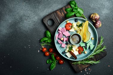 Peynir yaylası. Bal ve fındıkla servis edilen dilimlenmiş peynir. Kapatın. Karanlık bir taş arka planda.